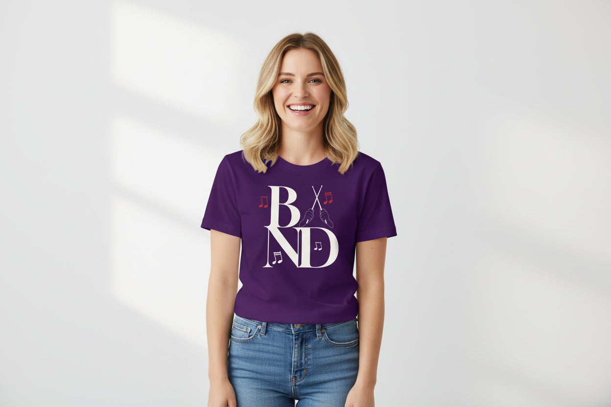 Person playing a snare drum with a music stand and 'BAND' t-shirt on a plain background